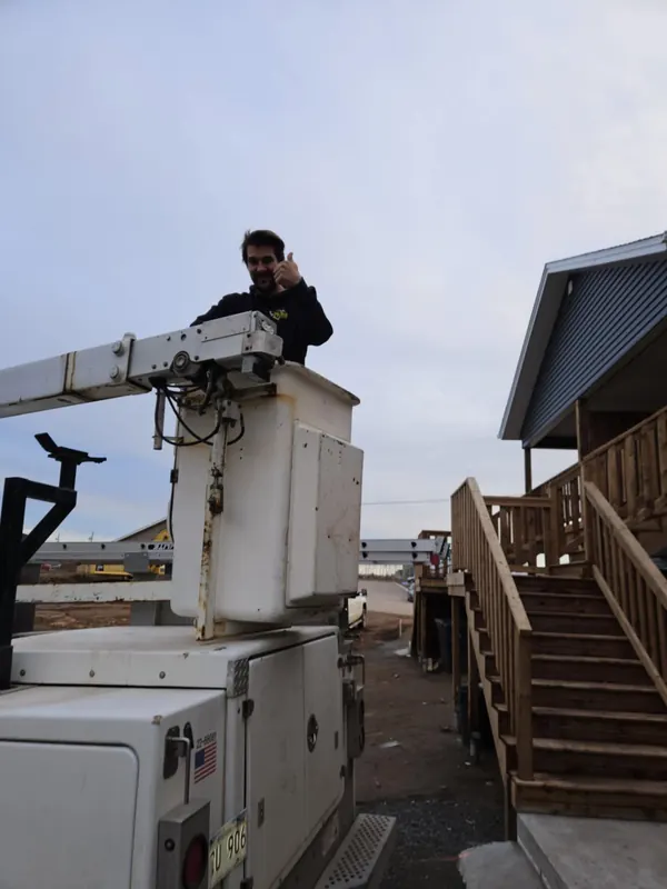 RJS team member giving a thumbs up from a bucket truck on a job site