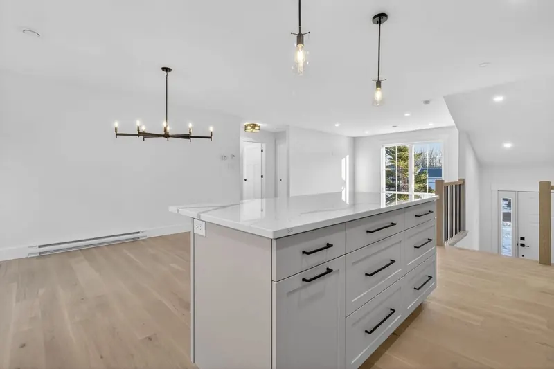 Finished kitchen island with pendant lighting and recessed pot lights