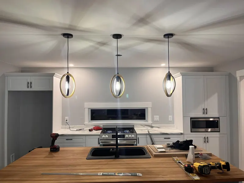Kitchen with pendant lights over a butcher-block island, work in progress