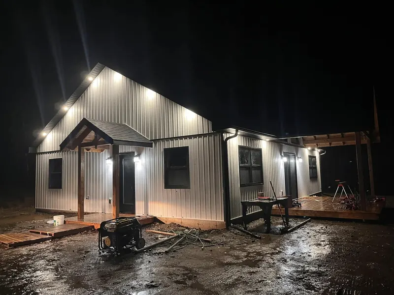 Metal-sided home lit up at night with soffit pot lights