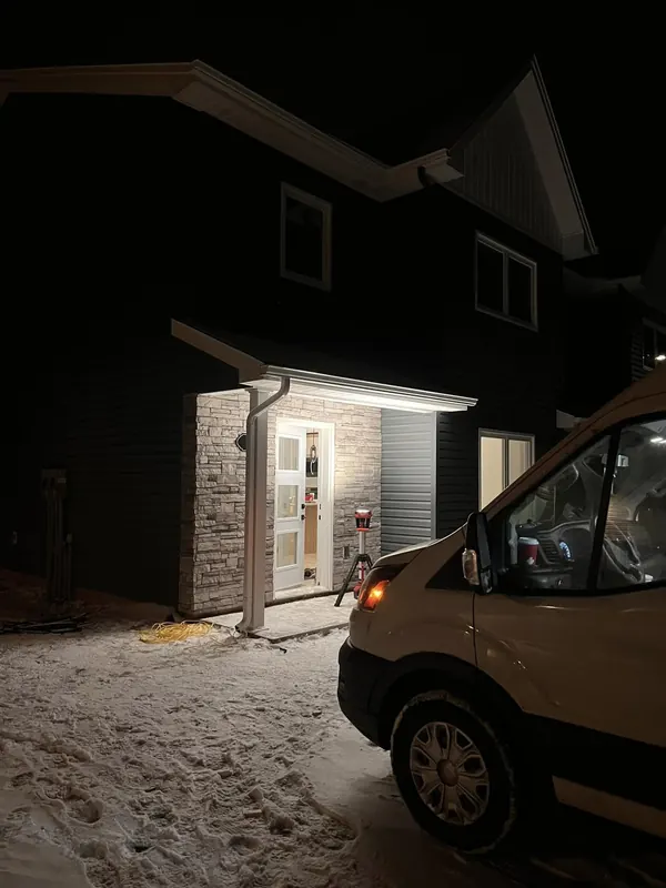 New-build home entry lit up at night with an RJS work van