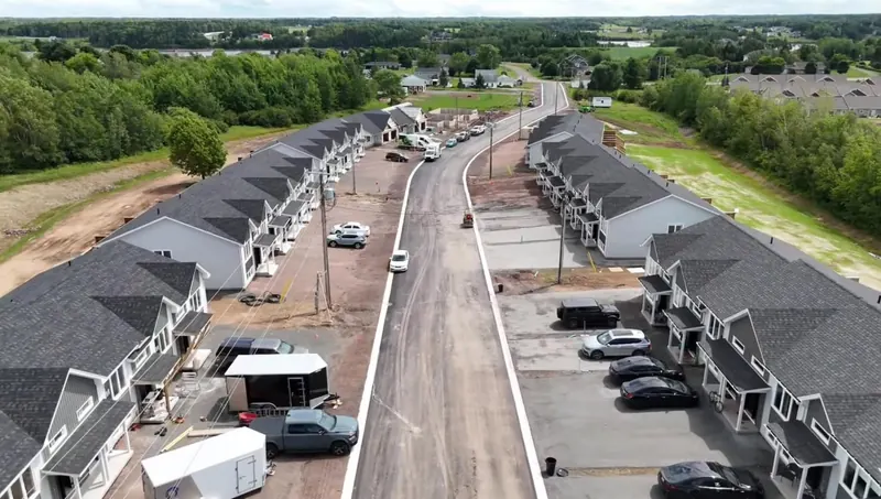 Aerial view of a new residential subdivision street lined with townhouses