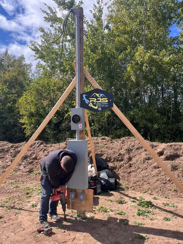 RJS electrician wiring a temporary power service pole